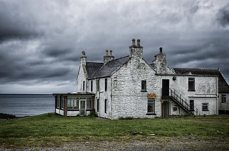 gray and black concrete house near body of water thumbnail
