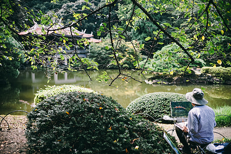 photo of man painting body of water and pagoda thumbnail