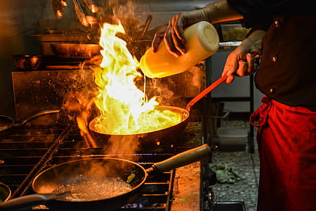 person cooking on black frying pan with fire on top thumbnail