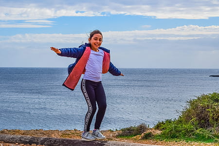 woman attempting to jump on ground near body of water thumbnail