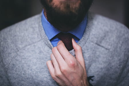 man in gray sweatshirt fixing necktie thumbnail