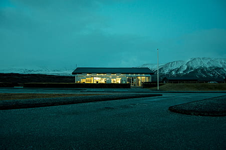 white concrete house near snow-capped mountain thumbnail