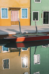 orange and black boat near gray road thumbnail