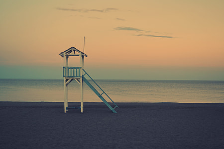 white and blue lifeguard house during golden hour thumbnail