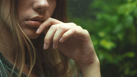 selective focus photography of woman's hand near green foliage plants thumbnail