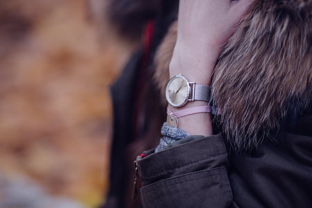 person wearing round gold-colored analog watch thumbnail