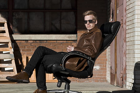 man sitting on rolling chair on focus photo thumbnail