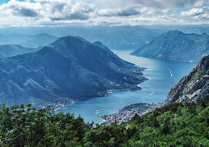 mountain near body of water under white clouds and blue sky during daytime thumbnail