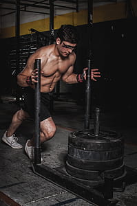Man Pushing Steel Frame With Pile of Weight Plates thumbnail