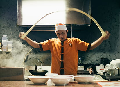 person in orange and black chef uniform baking thumbnail