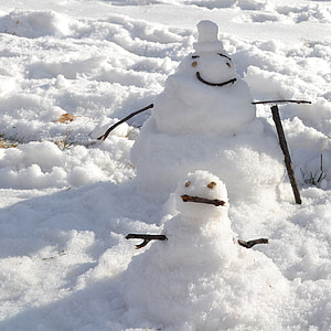 two snowman on snow-covered field thumbnail