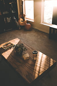 brown wooden coffee table and brown acoustic guitar near window thumbnail