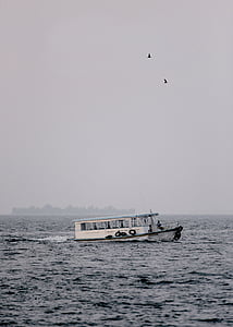 white boat on body of water with fog thumbnail
