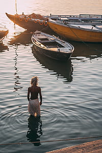 person in body of water near black boat thumbnail