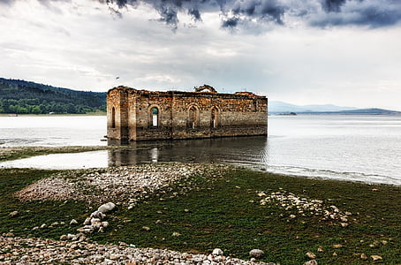 brown building in sea water under cloudy sky thumbnail