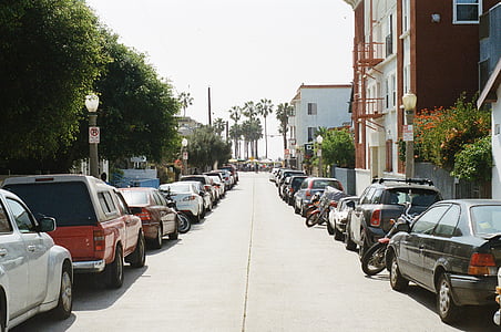 assorted-color vehicles on side of road during daytime thumbnail