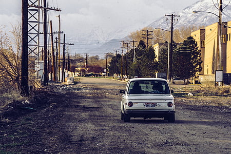 classic white car on road near buildings thumbnail