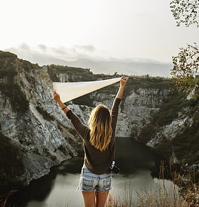 woman in black sweater and grey denim short shorts stands near lake during daytime thumbnail