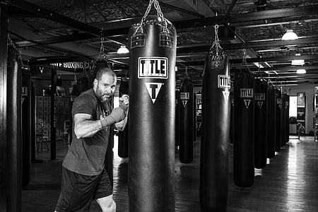 man punching on black leather heavy bag thumbnail