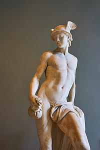 male Greek God statue near gray wall thumbnail