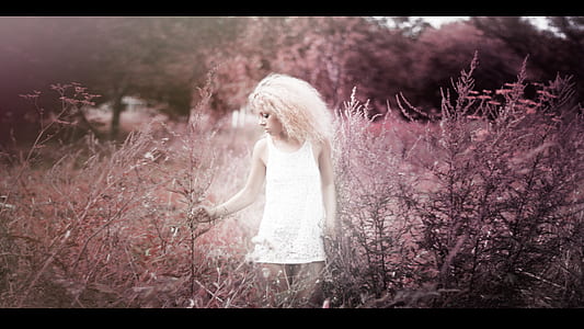 woman in white tank top standing in grass field thumbnail