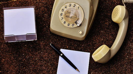 beige rotary phone beside pen thumbnail