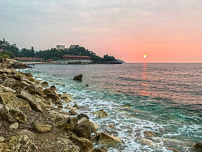 panoramic photography of building surrounded with trees beside body of water during golden hour thumbnail