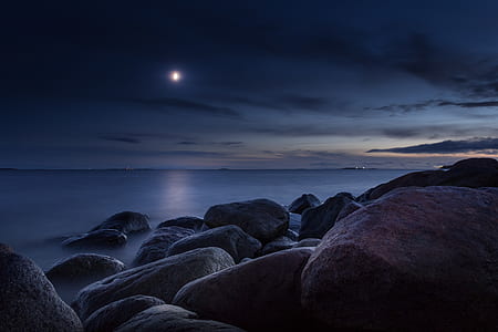 concrete rock fragments on body of water during night time thumbnail