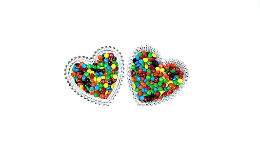 multicolored coated chocolates in heart shaped glass bowl thumbnail