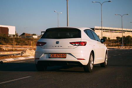 white SEAT Leon 5-door hatchback on gray concrete road thumbnail