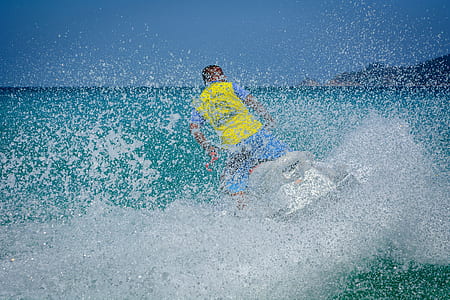 Man in Yellow Shirt Using Personal Watercraft thumbnail