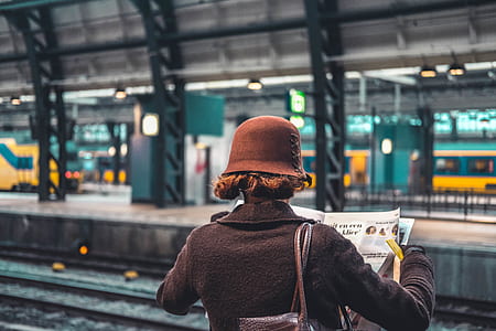 woman reading newspaper on train station thumbnail