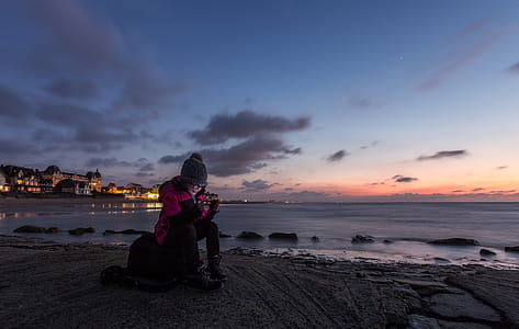 Person Sitting on Rock Near Water thumbnail