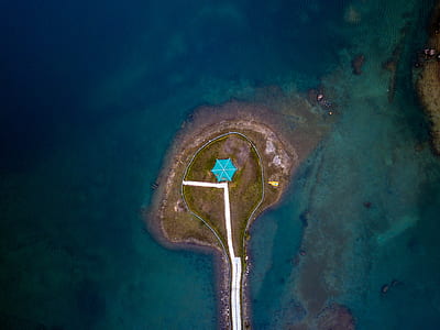 aerial photography of blue umbrella on island thumbnail