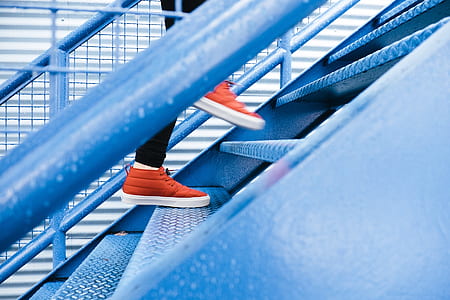 person stepping up blue steel stairs thumbnail