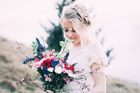 girl in white dress holding flower bouquet at daytime thumbnail