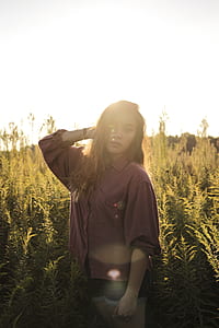woman standing near green plants thumbnail