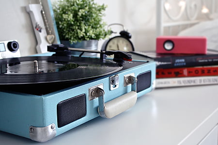blue and black turntable beside black media player and red speaker place on white table thumbnail