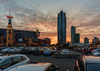 vehicles parked on road overlooking buildings at daytime thumbnail