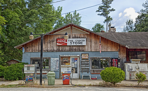 brown Coca-Cola the country store surrounded by trees during daytime thumbnail