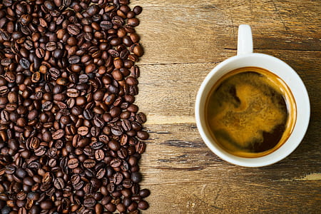 white ceramic coffee cup filled with coffee near coffee beans thumbnail