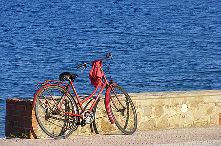 red bike parked on roadside thumbnail