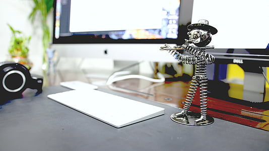 Apple magic keyboard near stainless steel spring human playing flute figurine thumbnail