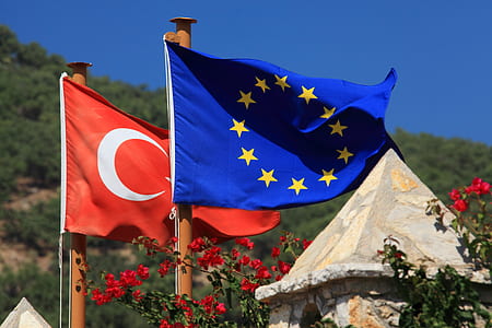 Turkey flag and Europe flag in poles under blue sky during daytime thumbnail