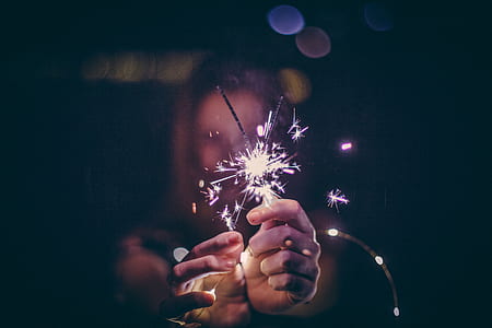 woman holding lighted sparklers at night thumbnail