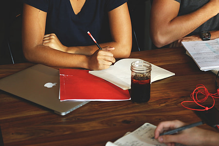 person sitting in front of table holding pen thumbnail