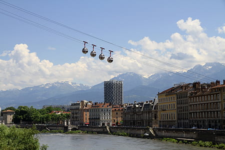 cable car near buildings above body of water thumbnail
