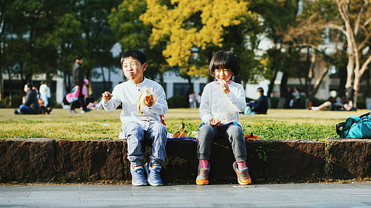 girl and boy sitting on concrete edge thumbnail