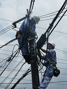 two linemen repairing cables on utility post thumbnail