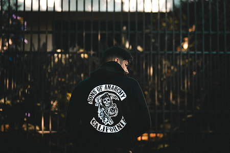 person in black and white jacket in front of gate thumbnail